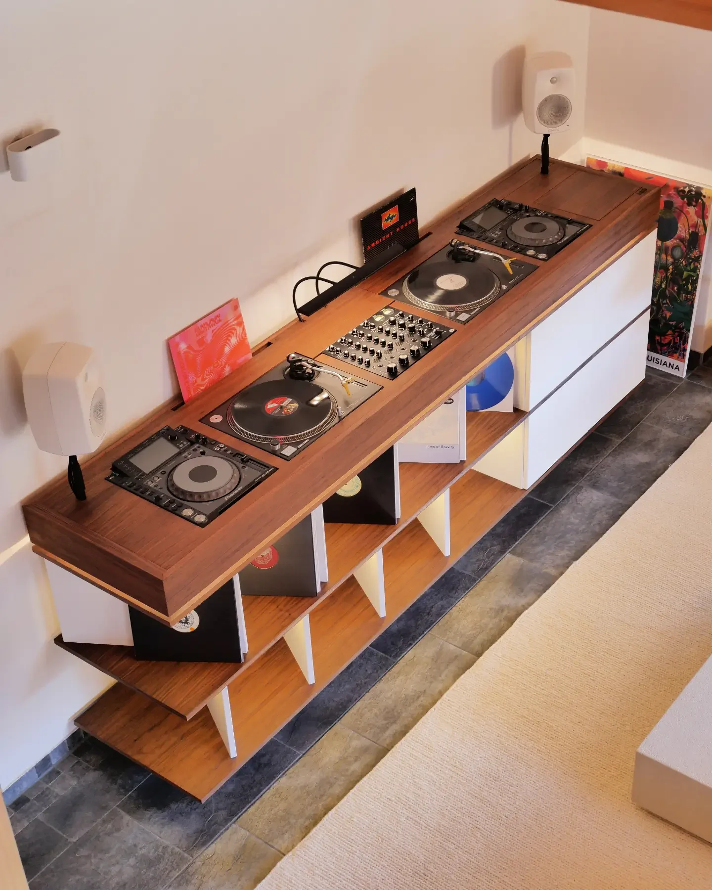 Vue plongeante sur une longue cabine en noyer avec deux lecteurs, deux platines et une table de mixage
