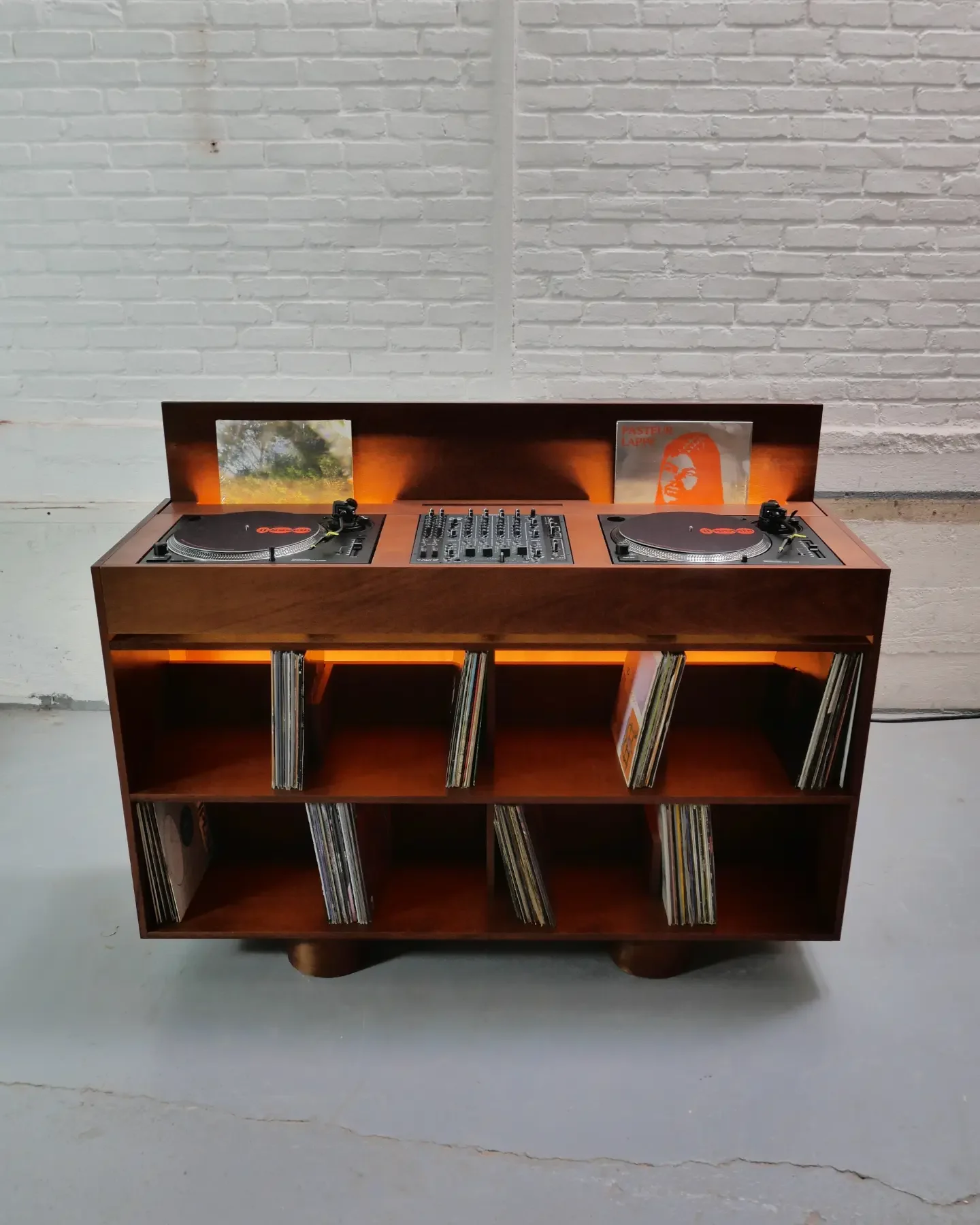 Cabine en bois teinté de face, ses bacs à vinyles éclairés en orange