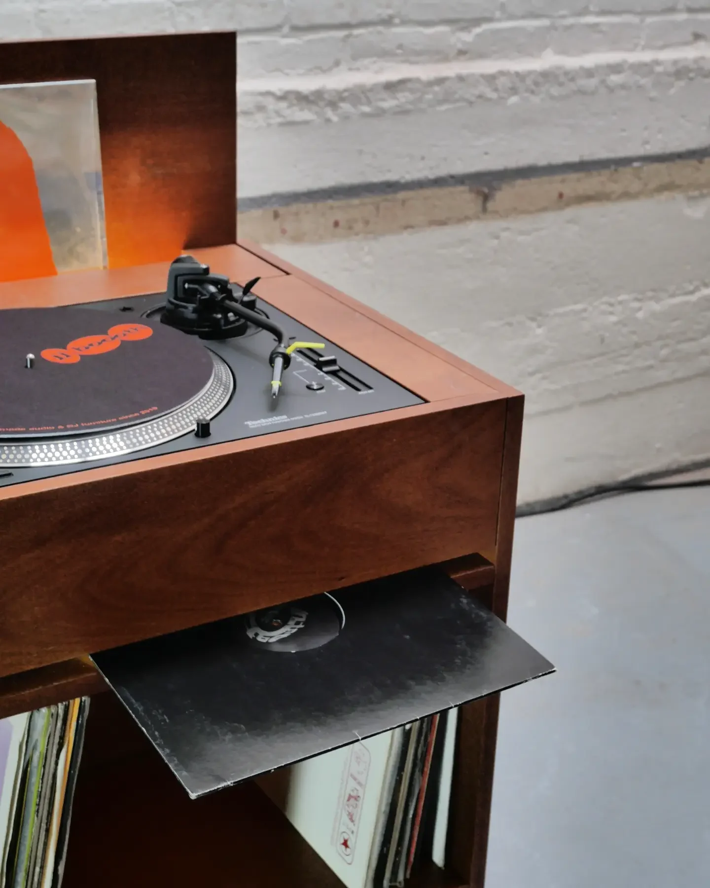 Détail d’une platine Technics encastrée et d’un vinyle tiré de son bac